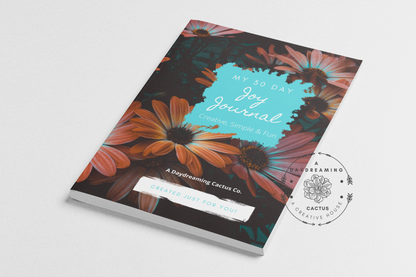 Mockup of A Daydreaming Cactus journal creation. This is the 30 Day Joy Journal with a orange pink and teal daisy cover.  