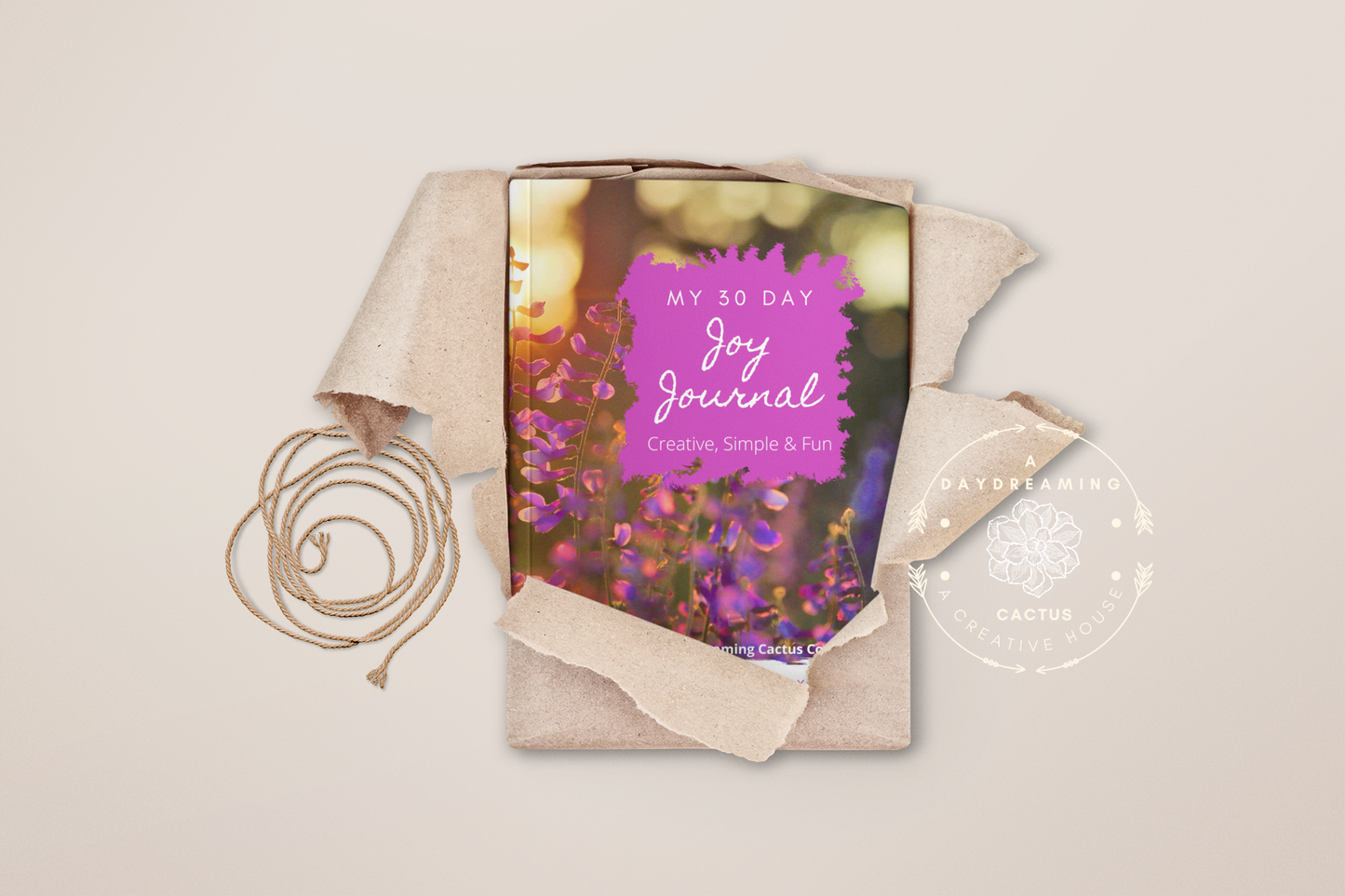 Mockup of A Daydreaming Cactus journal creation. This is the 30 Day Joy Journal with a lavender flowers cover wrapped in wrapping paper as a gift.