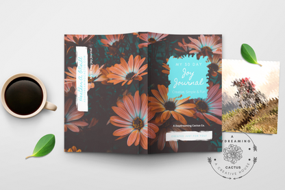 Mockup of A Daydreaming Cactus journal creation. This is the 30 Day Joy Journal with a daisy flowers cover with a cup of coffee.